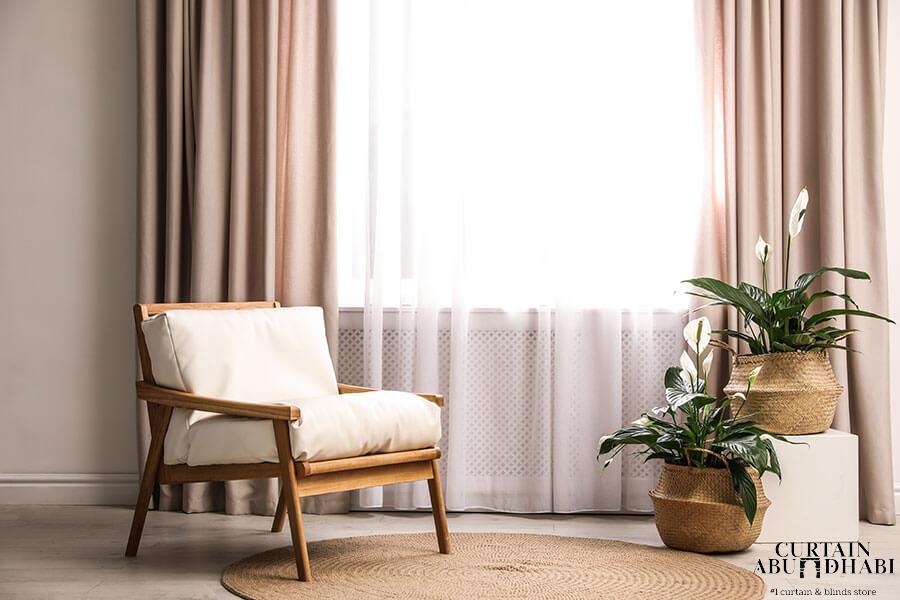 Comfortable armchair near window with elegant curtains in room